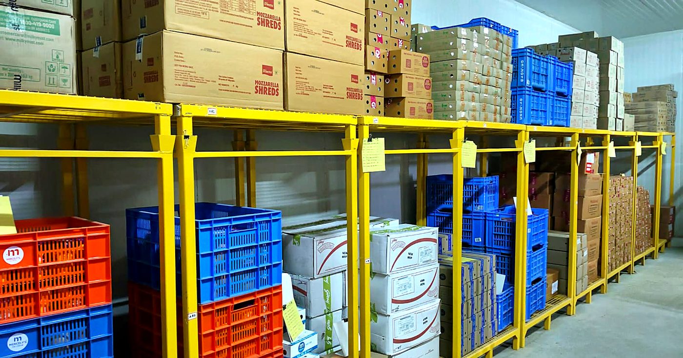Crates and mozzarella cartons on racking inside the Vilva Fruits cold storage in Coimbatore